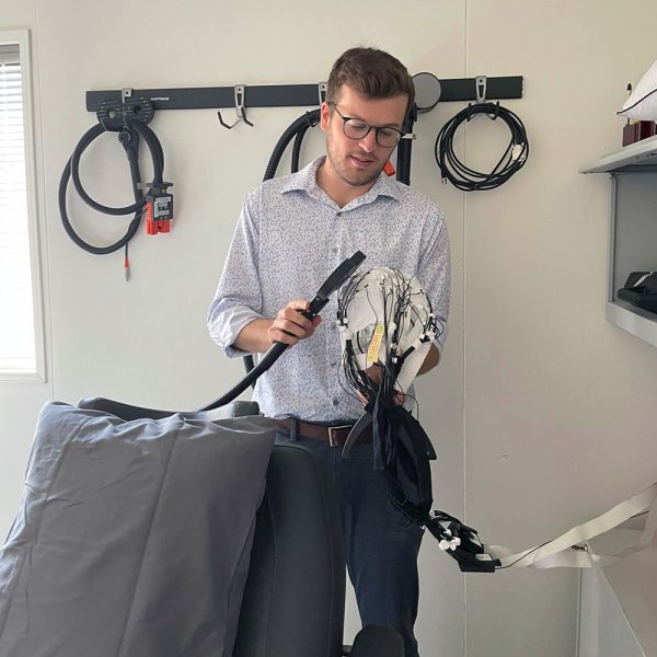 Noah Stapper in lab holding sensor and brain mapping electrodes.