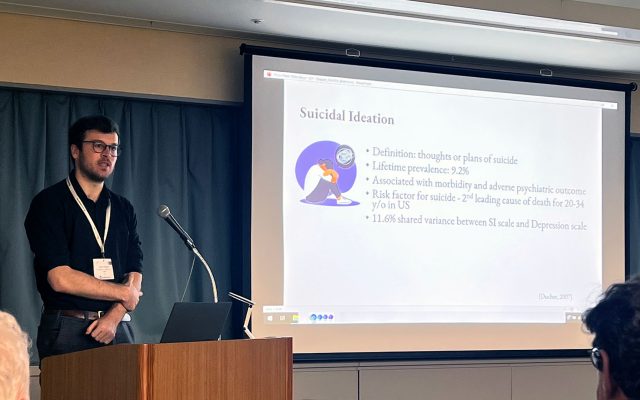 Noah Stapper at podium with slide on projection screen.