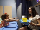 Charlize Rodriguez follows the instructions of doctoral student assistant Stephanie De Anda in a San Diego State University language research lab. SDSU is among several universities involved in a study to track children’s language development.  photo by JOHN GASTALDO • U-T