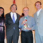 oicture of three individuals with Dr. James Sallis who is holding his award